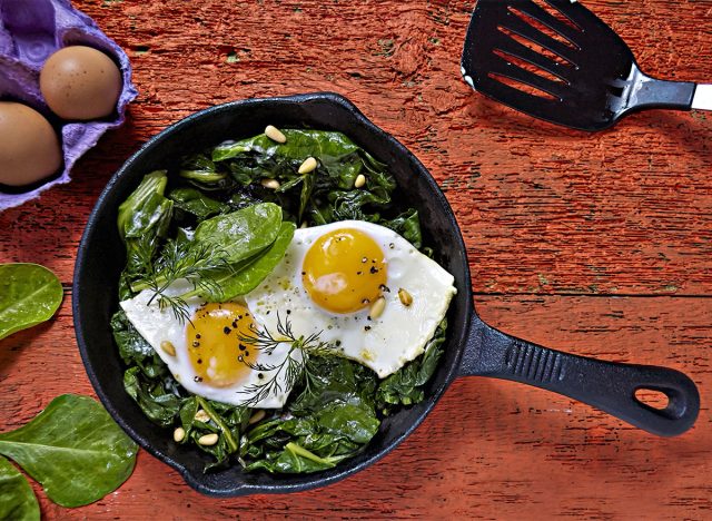 Fried eggs with spinach in a cast iron skillet